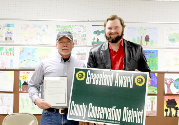 THE 2020 ROOKS COUNTY GRASSLAND AWARD was given to Jim and Donalee Circle and Cody and Jeff Dix. Receiving the award from Gregg Whisman (right), Rooks County Conservation District Chairman is Jeff Dix, left.