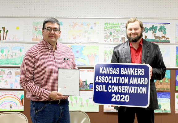 THE 2020 ROOKS COUNTY BANKERS AWARD was presented to Stamper Farm (Michael and Elizabeth Stamper, and Tony and Marcie Diaz). Tony Diaz, left, is shown accepting the award from Rooks County Conservation District Chairman Gregg Whisman (right).