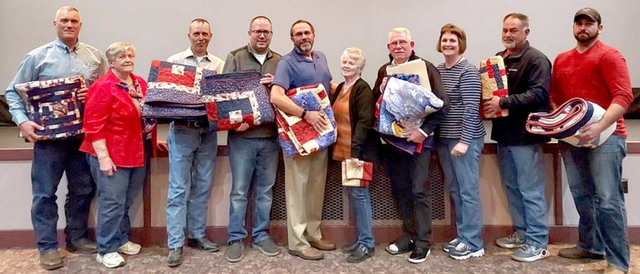 VETERANS RECEIVING A QUILT OF VALOR were pictured with the quilters at the Nova Theatre on Thursday, November 11th. They are Anthony Cole, quilter Judy Russ, David C. Atwood, Thomas J. Atwood, John D. Niermeier, quilter Diane Maddy, James Wagner, quilter Karen Reed, Robert Winters and Matthew Terry.