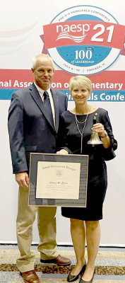 STOCKTON GRADE SCHOOL PRINCIPAL STACEY GREEN was honored at the NAESP conference in Chicago in early July as the 2020 National Distinguished Principal for the State of Kansas. Pictured are Kirk and Stacey at the award ceremony where she was presented with a bell and plaque.