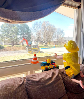 THIS LITTLE GUY wasn’t about to let Plainville’s big water line replacement project happen without him. Dressed head-to-toe in his construction gear and keeping a close eye from his front window, he made sure the crew across the street had all the supervision they needed. City construction is what you make of it—and this little foreman is making the most of it! (Courtesy Photo)
