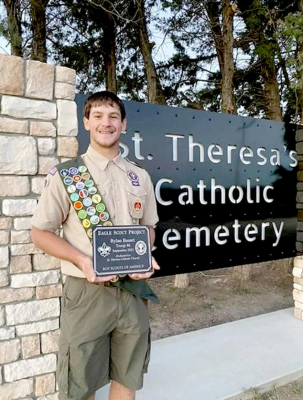 RYLAN BASART stands next to his completed Eagle Scout project...a new sign for St. Theresa’s Catholic Cemetery in Mankato.