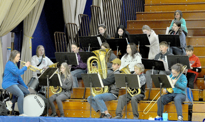 MRS. MEGAN RIENER (left), along with members of the Tiger Band, plays the school song during the Stockton vs. Osborne basketball games on Friday night.
