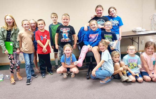 THE SUMMER PROGRAM MATH STUDENTS were at the Stockton USD 271 Board of Education meeting on Monday, October 9th to talk to the board members about how much fun they had while learning new math skills. Pictured are (from left, front row): Finley Peterson, Charlotte Berkley, Ned Berkley, Jax Miller, Coralie Armstrong; (middle row) Evelyn Hilbrink, Norah Muir, Emery Peterson, Hudson Horn, Henry Berkley, Trent Look, Lakota Miller, Jasper Miller; (back row) Tessa Look and Ava Armstrong.