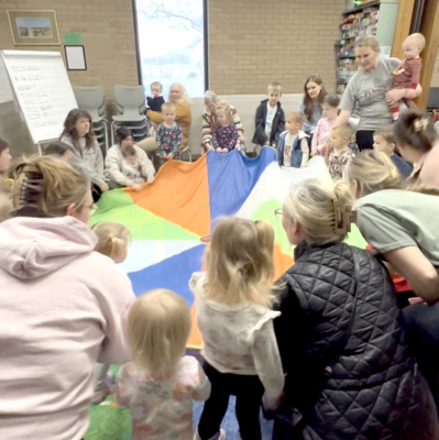 STORY TIME WITH STUFFIES and the entire group helping their Stuffies jump on the parachute.