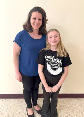 STOCKTON MUSIC TEACHER MEGAN RIENER poses with Emery Peterson at the 2025 Elementary All-State Choir event held in Wichita on Thursday, February 27th. Train,” “Vuela,” “Ad Astra,” “Hands Are Knocking,” and “The Climb.” Present for the performance were Emery’s family, Chelsey, Andy, and Finley, and Stockton music teacher Megan Riener.