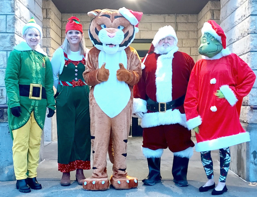 THE STOCKTON STUDENTS were greeted with plenty of High Fives on Friday, December 15th, when some very special guests showed up to wish everyone a great Friday! Posing for a picture before they took off to the North Pole and to perform other Christmas duties are Grade School Head Elf Stacey Green, High School Head Elf Lindsay Cravens, Tiger Troy Rogers, Santa Claus, and Grinch Superintendent Sarah Armstrong. Not pictured, are Toy Soldier Alexa Rogers and Holly who were also part of the greeting committee.