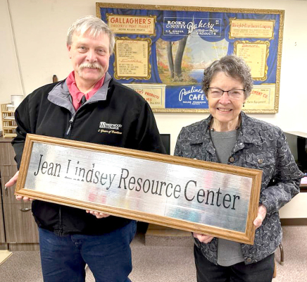 ROOKS COUNTY HISTORICAL MUSEUM DIRECTOR RICK GIANNI recently presented Jean Lindsey with the new sign for the Museum’s genealogical and resource center, which was been renamed the Jean Lindsey Resource Center.