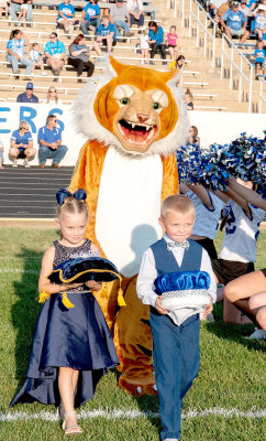 CROWN BEARERS Charity Balthazor and Cayson Earl accompany the Tiger mascot to the field during last Friday night’s Homecoming festivities.