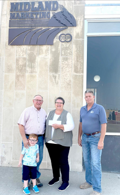 TOM BENOIT (far left), Land O'Lakes Board Member and Ryan Benoit (in front of Tom), Debi Kreutzman, Community Relations Manager for the Kansas Food Bank, and Kevin Royer CEO of Midland Marketing were on hand Friday, September 10, at Midland Marketing in Hays, where an announcement was made of Midland Marketing and Land O’ Lakes donating $15,000 to the Kansas Food Bank.