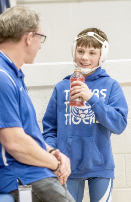 SJH WRESTLER ELI ATKISSON appears relaxed as he visits with his coach, Clint Bedore, prior to hitting the mat for the Stockton Junior High Round Robin held last Thursday.
