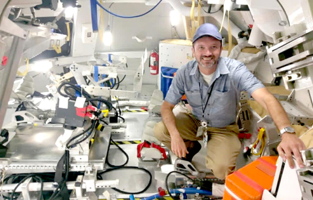 A DREAM COME TRUE: Travis inside Space Shuttle Discovery, stepping into the legacy of space exploration.
