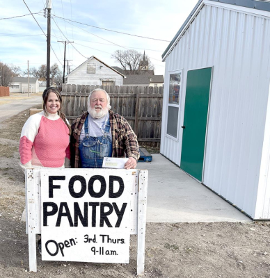 KENZIE GRIFFITHS (left) with Prairie Land Electric, is shown with Mike Rogers, representing the Stockton Food Pantry. The cooperative held a holiday challenge for its 84 employees, hoping each employee would donate 10 items to go towards their local food banks in the areas they serve. Their contributions far exceeded expectations—1,573 pantry items and $910. The Stockton Food Pantry received three boxes of food, a donation check and cash to help towards providing food for those in need.